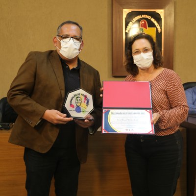 A Vereadora Vanja Honorina (PSD) entrega o troféu e certificado ao 4ª colocado da premiação: professor Osmar Manuel