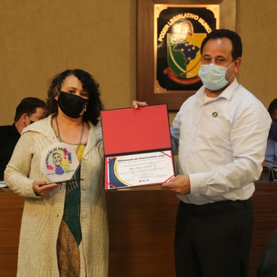 O Vereador Gilberto Brandão (Avante) entrega o troféu e certificado a 5ª colocada da premiação: professora Maria Rozeni