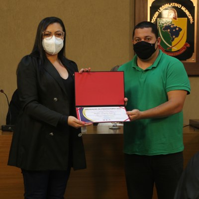 O Vereador Marco Cardoso (Marcão Paraíso) (PSDB) entrega certificado à avaliadora Mariana Souza, representante da Secretaria Municipal de Educação.