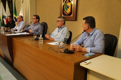Mesa Diretora  Ao centro, Vereador Edenilson, que dirigiu os trabalhos  à esquerda, o Deputado Estadual Ioannis Konstantinos (Grego) (PMN); e o diretor administrativo do Hospital São Sebastião (HSS), Ronaldo Oliveira,; à direita, o Diretor Administrativo do Hospital do Câncer de Muriaé da Fundação Cristiano Varella, Sérgio Henriques; e o diretor administrativo Hospital São João Batista (HSJB), Belmiro Filho.