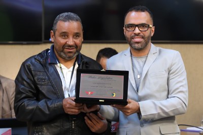 Entrega de Placa alusiva em homenagem a Edmilson Anjos dos Santos, primeiro aluno com deficiência visual a concluir o curso de Pedagogia da Universidade Federal de Viçosa, destacando sua trajetória, que não representa apenas uma conquista pessoal, mas também um marco histórico para a promoção da acessibilidade, inclusão e equidade no ensino superior público brasileiro