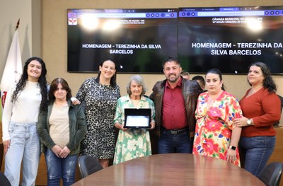 Entrega de placa alusiva à Senhora Terezinha da Silva Barcelos, em reconhecimento por sua dedicação e contribuição à comunidade viçosense