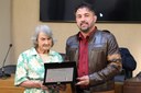 Entrega de placa alusiva à Senhora Terezinha da Silva Barcelos, em reconhecimento por sua dedicação e contribuição à comunidade viçosense